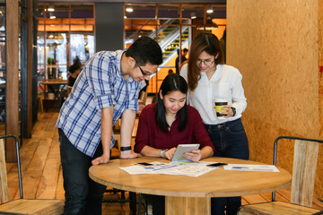 Group of three casual business meeting to discuss ideas and laptop on table in coffee shop.