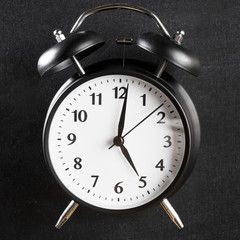 Close-up of an alarm clock on black background