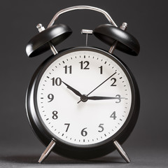 An alarm clock on black backdrop
