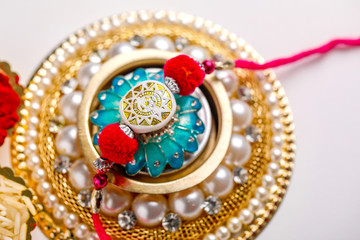 Indian festival Raksha Bandhan , Rakhi with rice grains, kumkum on Decorative plate , A traditional Indian wrist band which is a symbol of love between Brothers and Sisters