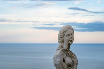 Fototapeta na wymiar Women Statue from the belvedere, the so-called Terrazza dell'infinito, The Terrace of Infinity seen on the sunset, Villa Cimbrone, Ravello village, Amalfi coast of Italy