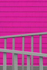 Pink shingle wall with grey fence