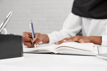 Selective focus of female writing in notebook