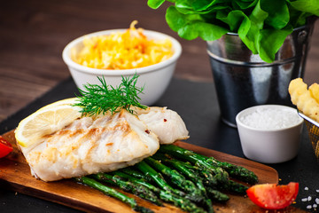 Fish dish - fried fish fillet with french fries and vegetables