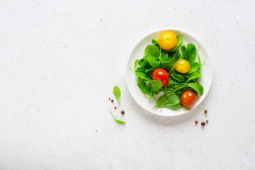 Healthy vegetable salad of fresh arugula and colorful tomatoes. Health care, detox, fitness, diet concept.