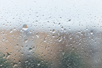 Raindrops on the window glass with blurred background.