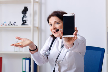 Middle-aged female doctor in telemedicine concept