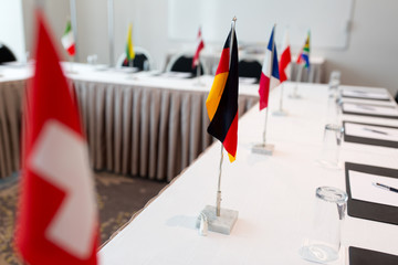 business, corporate and interior concept - flags on table in boardroom at international conference