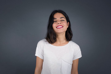 Obraz premium Horizontal portrait of pleasant-looking Caucasian female with long beautiful hair wearing brown sweater covering her face with hair looking happily to the camera.