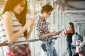 Man and woman traveller checking flight in smartphone at the airport terminal.