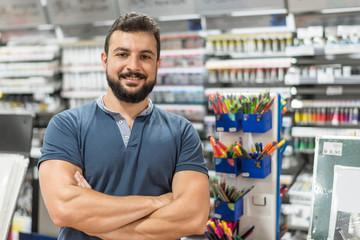 attractive worker in stationery poses with arms crossed looking at camera - obrazy, fototapety, plakaty