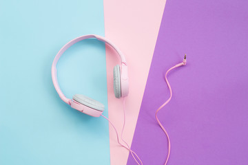 Pink headphones on color background. Music concept
