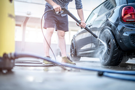 Mann putzt sein Auto mit dem Kärcher Hochdruckreiniger