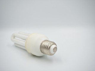 Left sided shot on the used energy saving bulb with screwbase and the isolated white background