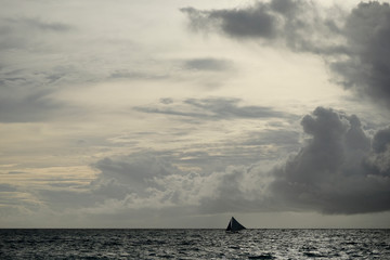 One small yacht on wide sea horizon in boracay Philippine. Magnificent sunset clouds