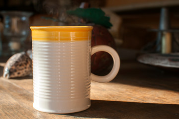 Ceramic tea mug closeup on wooden board surface