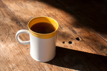 Ceramic tea mug closeup on wooden board surface