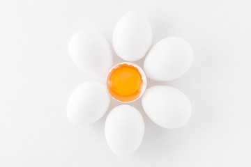 fresh white eggs with yolk on white background, flat lay