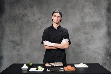 Chef man in the kitchen at the restaurant. Ingredients for sushi and rolls.