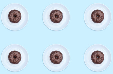 Chocolate donut pattern on a plate on a blue background. ..