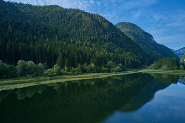 Fototapeta na wymiar Aerial photography. Panoramic view of a small lake north of Italy. Trento region. Great trip to the lake in the Alps.