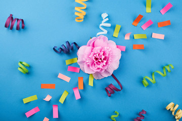 Pink flower with color papers on the blue background