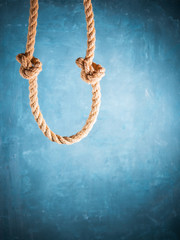 Jute rope hanging from above on dark blue background.