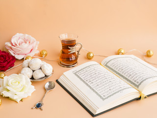 Fototapeta na wymiar Opened quran on festive table with flowers