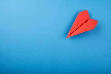 Red paper plane on the blue background