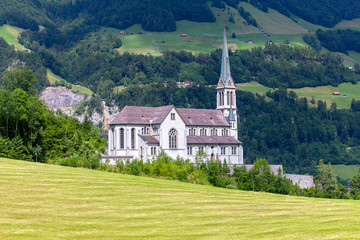 Fototapeta na wymiar Lungern Old stone catholic church in swiss village.
