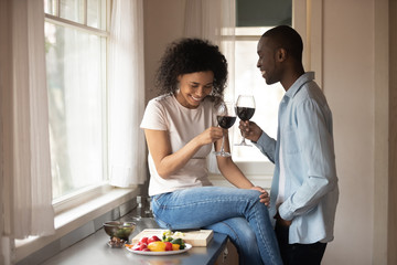 Black couple enjoy romantic date with wine in the kitchen