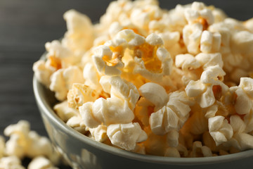 Bowl with popcorn on wooden background, close up