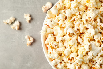 Bucket with popcorn on grey background, space for text