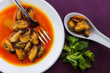 MUSSELS IN ORANGE SAUCE ON WHITE DISH AND LEMON ROLL WITH LETTUCE