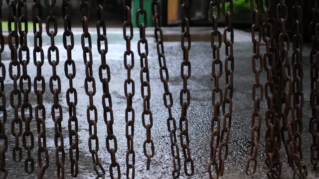 The metal chain is swinging. Heavy metal chain pendulum moves