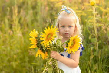 Portrait of a little girl with a bouquet of sunflowers