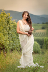 Young woman in tunic harvesting grapes