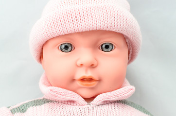 Cute baby doll fase in knitted dress close up