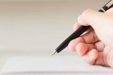 Hand writing something on the paper with copy space