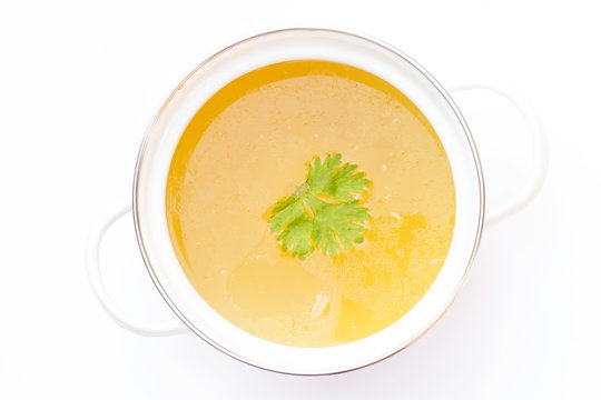 Pot of chicken broth isolated on white background.