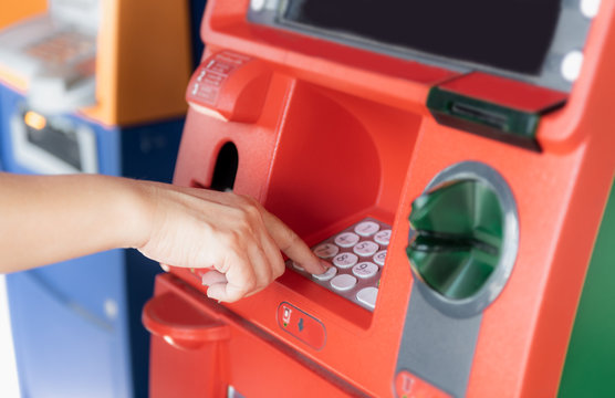 Closed up woman hand withdraw money from ATM machine.