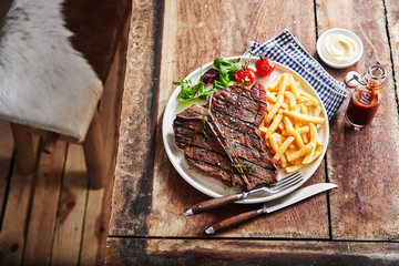 Barbecued T-bone steak with French fries