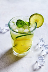 Lemonade with lime and ice in a glass viewed from above. Summer refreshment. 