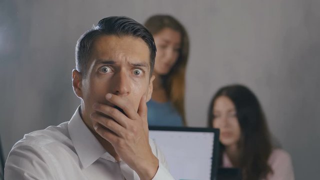 Businessman shocked and surprised while reading a message in the smartphone at office background. Man scared when he heard bad news in office