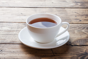 Cup with chicory drink and blue chicory flowers on wooden table. Copy space.