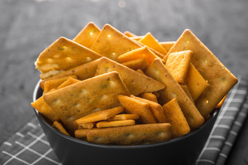 Black bowl with crackers on a dark concrete background