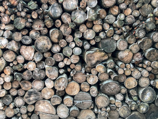 Wood texture for the background of sawed tree trunks. Warehouse of firewood for heating, fires, fireplaces.