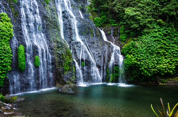 Banyumala Twin Waterfalls. Jungle waterfall cascade in tropical rainforest with rock and turquoise blue pond. Bali, Indonesia. 
