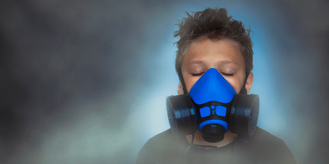 Young boy wearing gasmask, respirator portrait. Effects of worldwide air pollution, industrial...