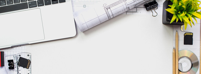 Architectural plans, pencil and ruler on the table. Laptop and accessories. Place for your text.